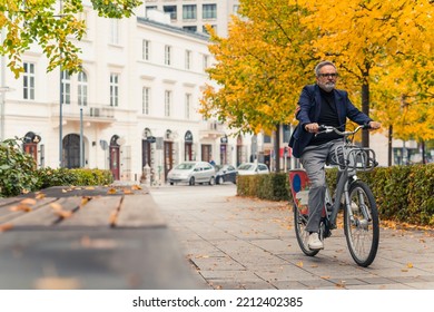 Fall outdoor activities. Full-length shot of middle-aged caucasian bearded man in business casual clothing riding a rented bike. Autumn in the city. High quality photo - Powered by Shutterstock