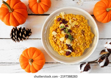 Fall Pumpkin Risotto With Cranberries And Parmesan Cheese. Top Down Table Scene On A White Wood Background.