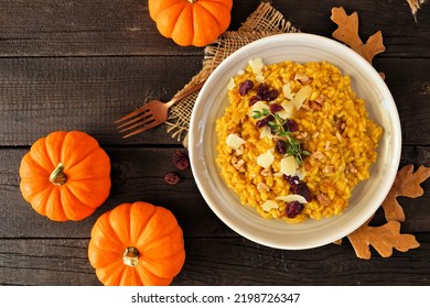 Fall Pumpkin Risotto With Cranberries And Parmesan Cheese. Overhead View Table Scene On A Rustic Wood Background.