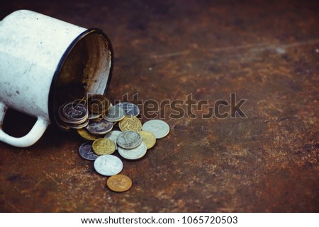 the fall of the Russian ruble, poverty and poverty scattered coins in the old mug on a rusty background, sanctions.