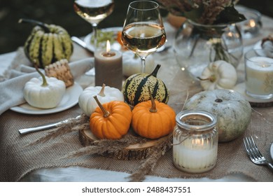 Fall table decoration with pumpkins, wine. Family thanksgiving dinner arrangement outdoors in the garden. Countryside style, simple handmade setting, autumn mood, inspiration - Powered by Shutterstock