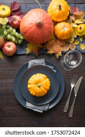 Fall Table Place Setting With Orange Dry Leaves And Pumpkins. Vertical Format. Centerpieces Thanksgiving Day. View From Above.