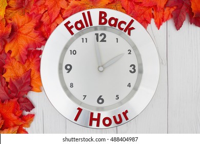 Fall Time Change, Some Fall Leaves And A Clock On Weathered Wood With Text Fall Back 1 Hour