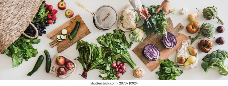 Fall vegetarian cooking background. Female hands cutting greens over table with fresh seasonal vegetables, greens, fruit from local grocery market, top view. Vegan, healthy, organic food - Shutterstock ID 2070710924