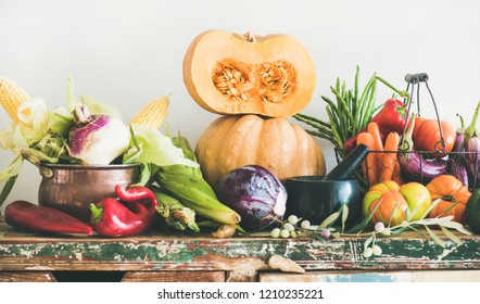 Fall Vegetarian Food Ingredient Variety. Assortment Of Various Autumn Vegetables For Healthy Cooking Over Wooden Rustic Cupboard, White Wall Background. Local Market Organic Produce