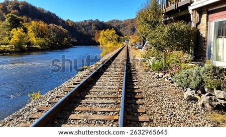 a fall view of train tracks that run alongside the French Broad river  in Marshall, NC