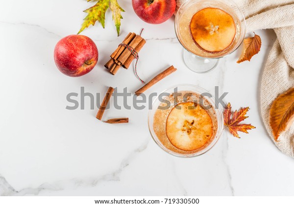 Fall and\
winter drinks, Apple cider martini margarita with cinnamon and\
apple garnish, on white marble table, copy\
space