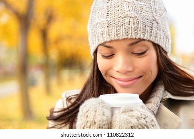 Fall Woman Drinking Coffee In Autumn City Park. Girl Enjoying Hot Drink From Disposable Coffee Cup. Fall Lifestyle Concept With Beautiful Young Mixed Race Chinese Asian / Caucasian Female Model.