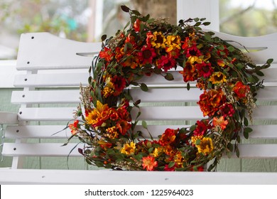 Fall Wreath Sitting On A Porch Swing