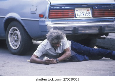 Fallen homeless man laying on city street, Los Angeles, California