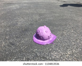Fallen ice cream ball melting on hot ground.