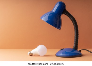 A Fallen Light Bulb From A Table Lamp, A Blue Light And An LED Lamp. Requiring Replacement