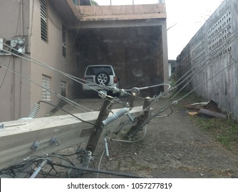 fallen post in front of a house after hurricane maria in Puerto Rico