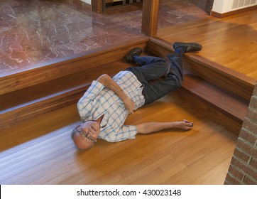 Fallen senior man activating an electronic device in his hand to call for help - Powered by Shutterstock