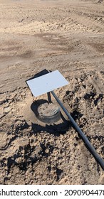 A Fallen Sign In A Dirt Lot For Real Estate Property.