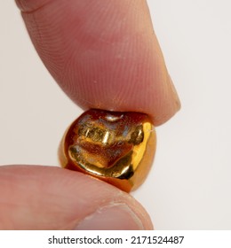 A Fallen Tooth With Gold Crown In The Hand Of An Elderly Man