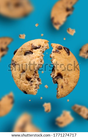 Falling broken chocolate chip cookies isolated on blue background with clipping path, flying biscuits collection