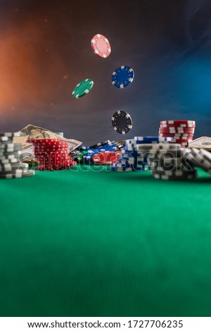 Falling chips on a poker table in a casino. Online poker bets.