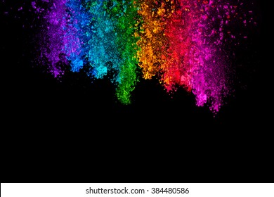 Falling colored powder. Rainbow of purple, blue, green, yellow, red and pink dust over black background with copy space for text