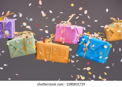 Falling Confetti Near Colorful Presents On Grey 