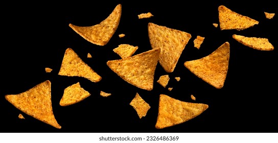 Falling corn chips, hot Mexican nachos isolated on black background