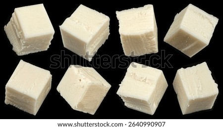 Falling cubes of white cheese isolated on black background