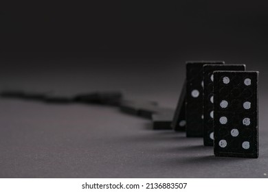 Falling dominoeson dark background. domino effect. the domino game.