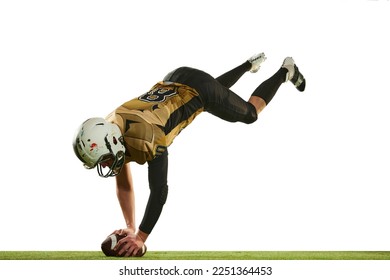 Falling down with ball. Man, american football player in motion, training over white studio background with green grass flooring. Concept of sport, movement, achievements, competition, hobby - Powered by Shutterstock