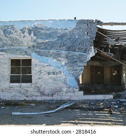 Falling down building with winter scene mural painted on side.