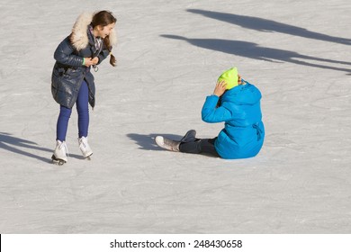 Falling Down Teenager On The Ice Rink And Ice Skating At The Medeo