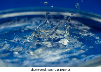 Falling Droplets Breaking Water Surface And Ensuing Ripples