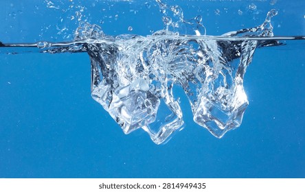 Falling ice cubes in motion with splashing water, creating air bubbles scatter around, blue background isolated. Ice cubes fall into water with air bubbles