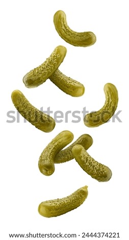 Falling marinated pickled cucumbers isolated on white background, clipping path, full depth of field