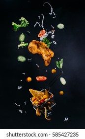 Falling meat and vegetables on the black background. Abstract picture. Yummy food
