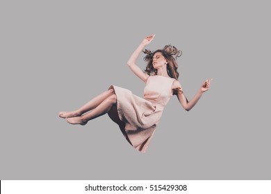 Falling in motion. Studio shot of attractive young woman hovering in air
