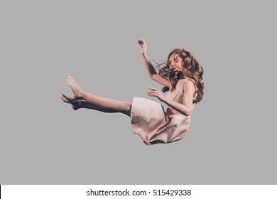 Falling to nowhere. Studio shot of attractive young woman hovering in air