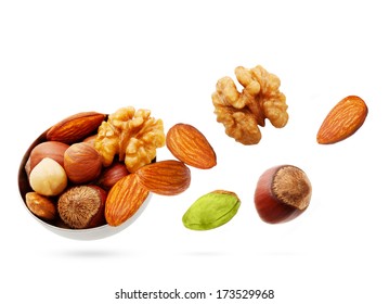 Falling Nuts In Bowl Isolated On White Background.