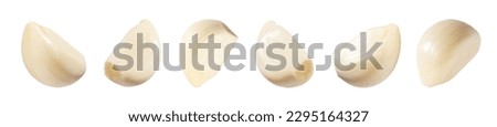 Falling peeled garlic cloves isolated on white background with clipping path. Food and spices objects for design. Spicy and fragrant seasoning concept.