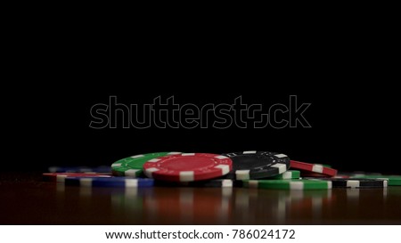 Falling poker chips isolated on black background. Colorful poker chips falling at the table on black background. Playing chips flying at the black background