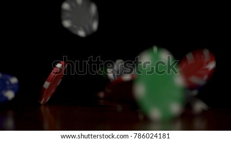 Falling poker chips isolated on black background. Colorful poker chips falling at the table on black background. Playing chips flying at the black background