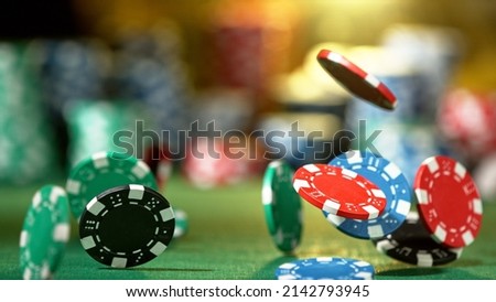 Falling poker chips on the table, macro shot. Casino and gambling concept.