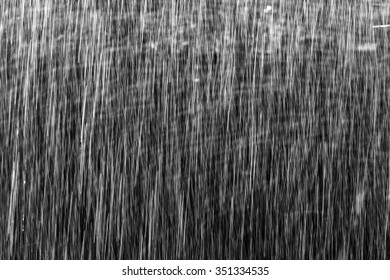Falling raindrops on black background.