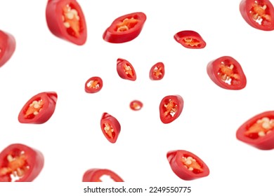 Falling sliced red hot chili peppers isolated on white background, selective focus