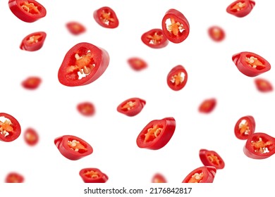 Falling sliced red hot chilli peppers isolated on white background, selective focus