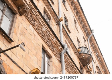 Falling snow gently envelops a historical building in the center of Minsk, Belarus, creating a serene winter scene with a blend of architectural charm and snowy ambiance - Powered by Shutterstock