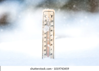 Falling snow in winter and a thermometer.