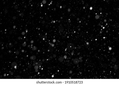 Falling snowflakes on night sky background, isolated for post production and overlay in graphic editor. Bokeh of white snow on a black background.