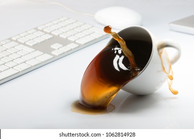 Falling And Spilling Of A Cup Of Coffee On Top Of A Desk With A Computer