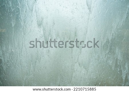 Falling water on glass wall , blurred background.
