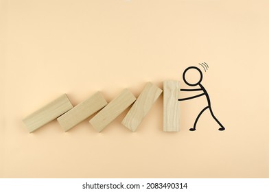 Falling wooden blocks, drawn by a person holding them. the concept of strength, leadership, resistance. Wooden cubes fall like dominoes, leaning on the wall, which is held by the drawn man.